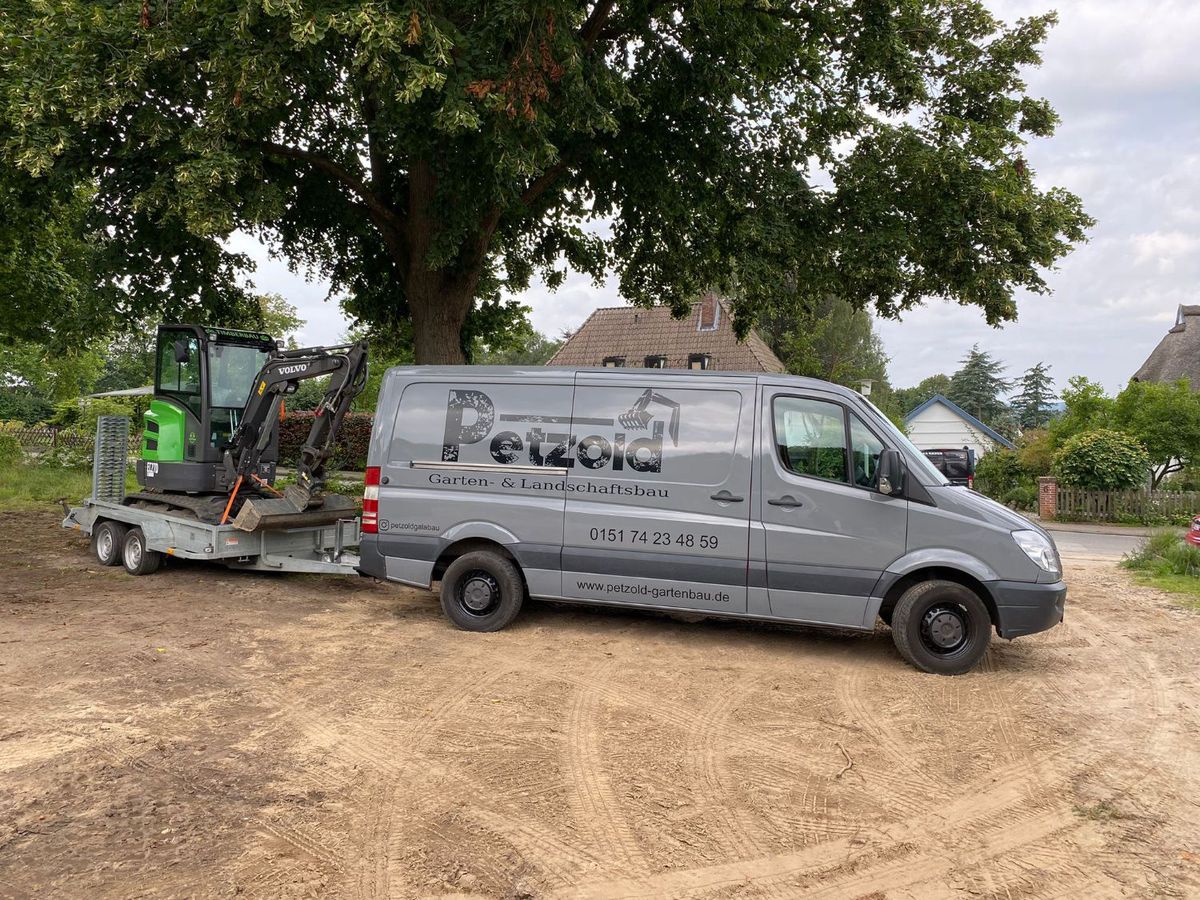 Petzold-Sprinter mit Beschriftung und Minibagger auf dem Anhänger